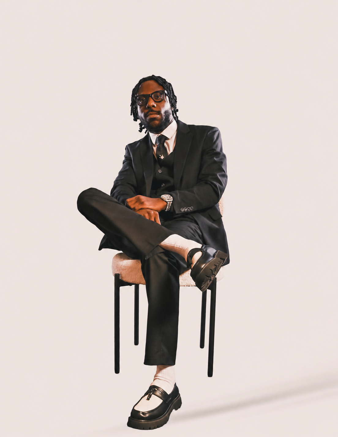Lando Akeem seated in a black suit